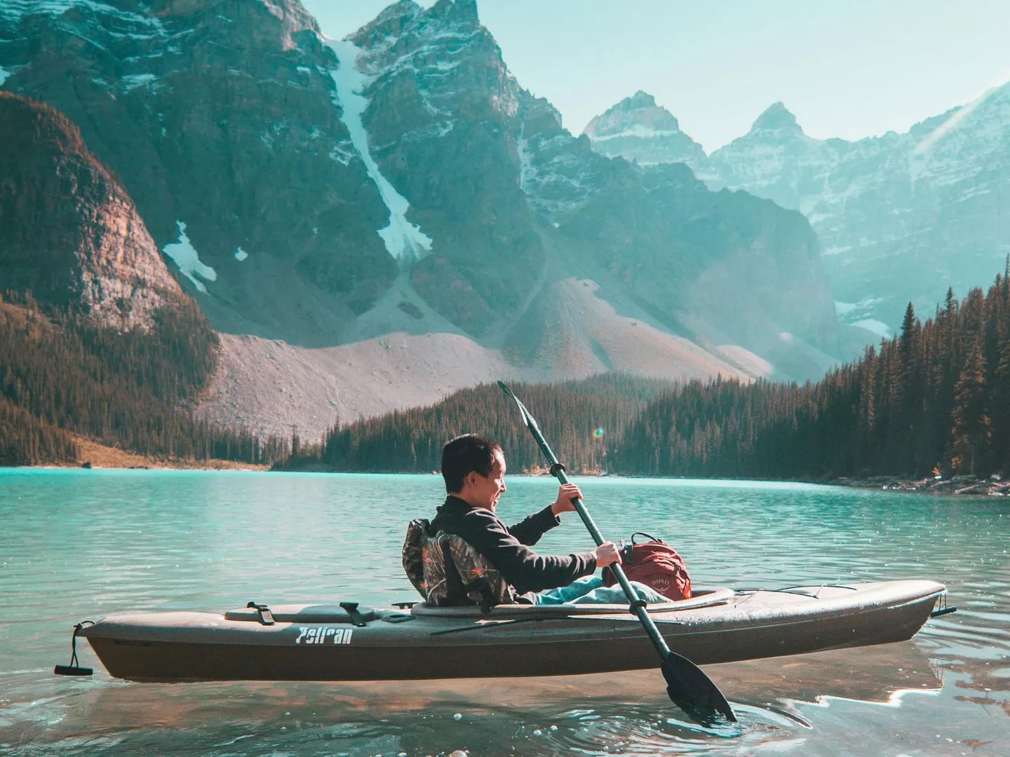 A person on a kayak with mountains in the background